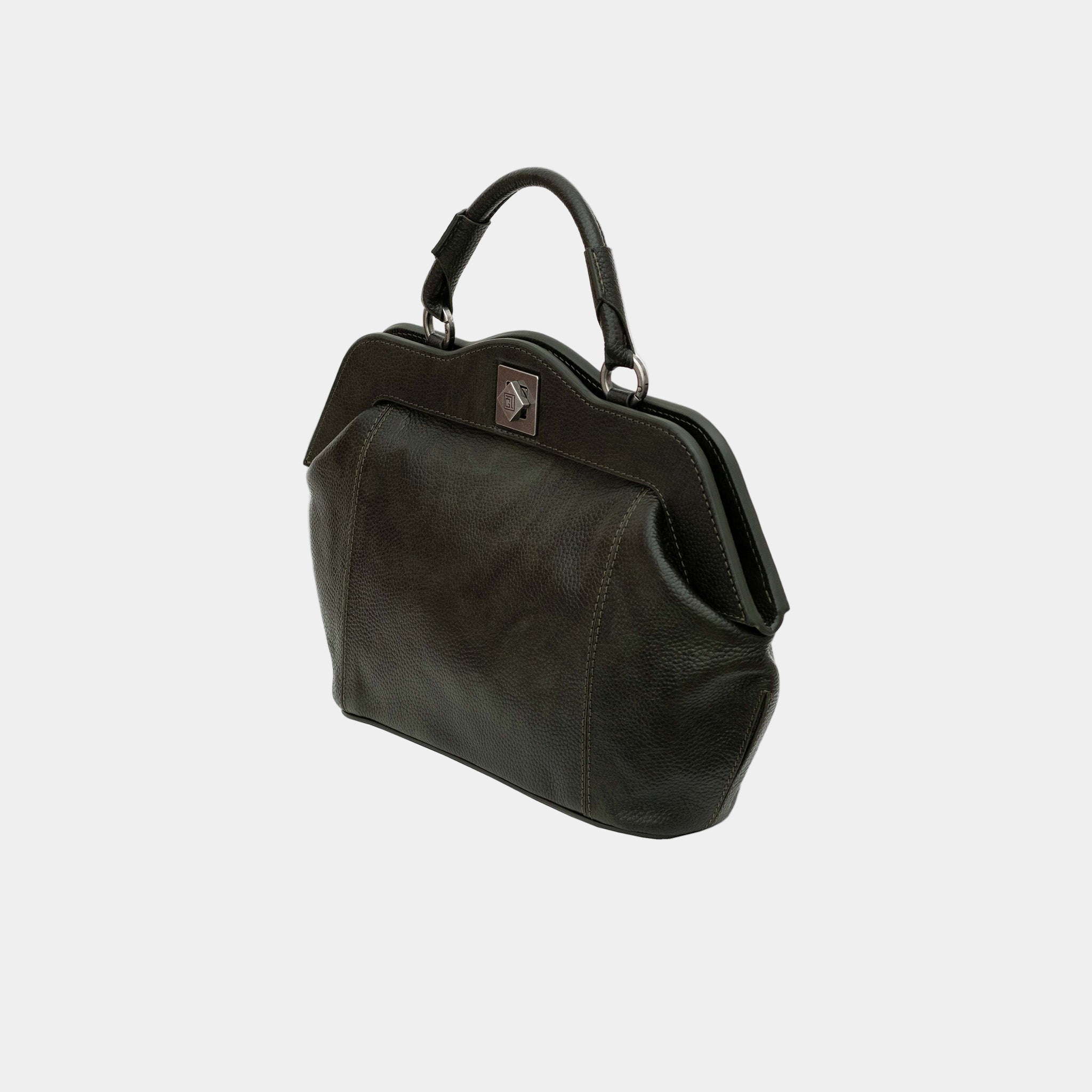 Side angle of the Dolly bag – sculptural silhouette and curved frame in black leather