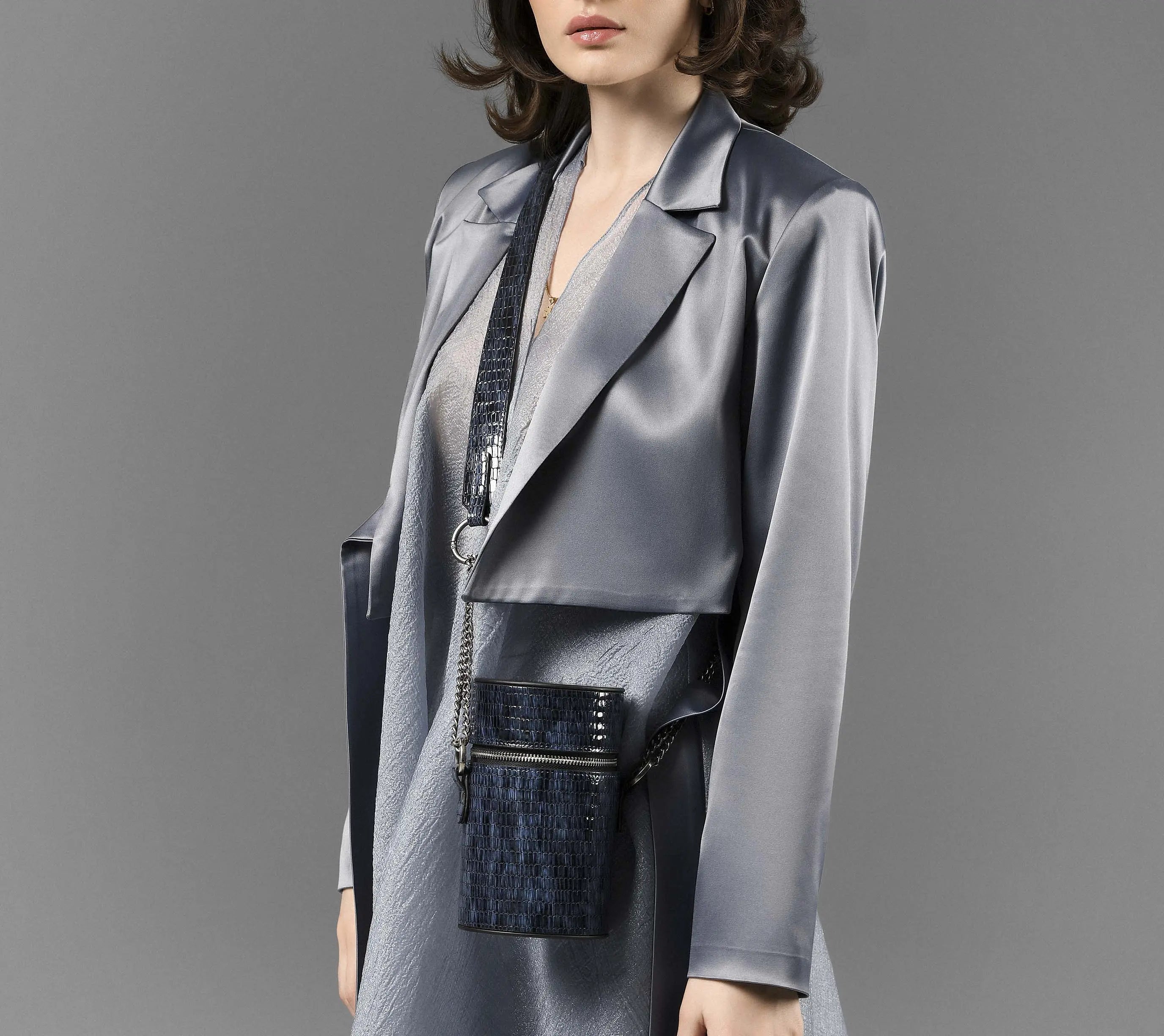 Model wearing Baia blue croc-embossed cylindrical leather shoulder bag crossbody