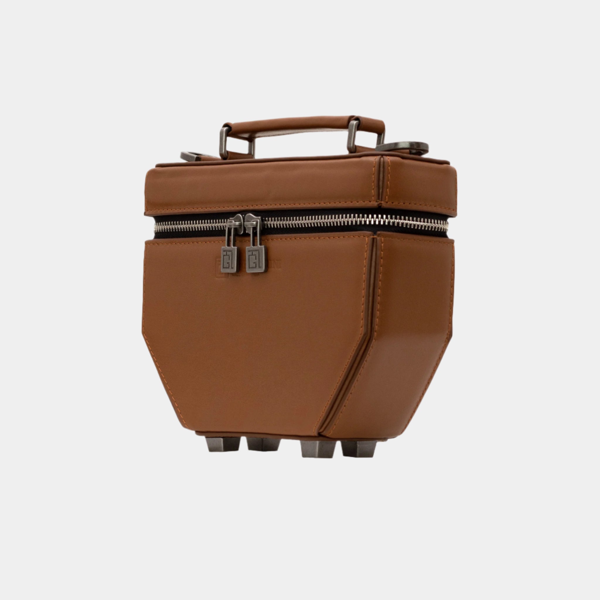 Angled view of structured cognac Eileen bag with geometric lines and metal feet