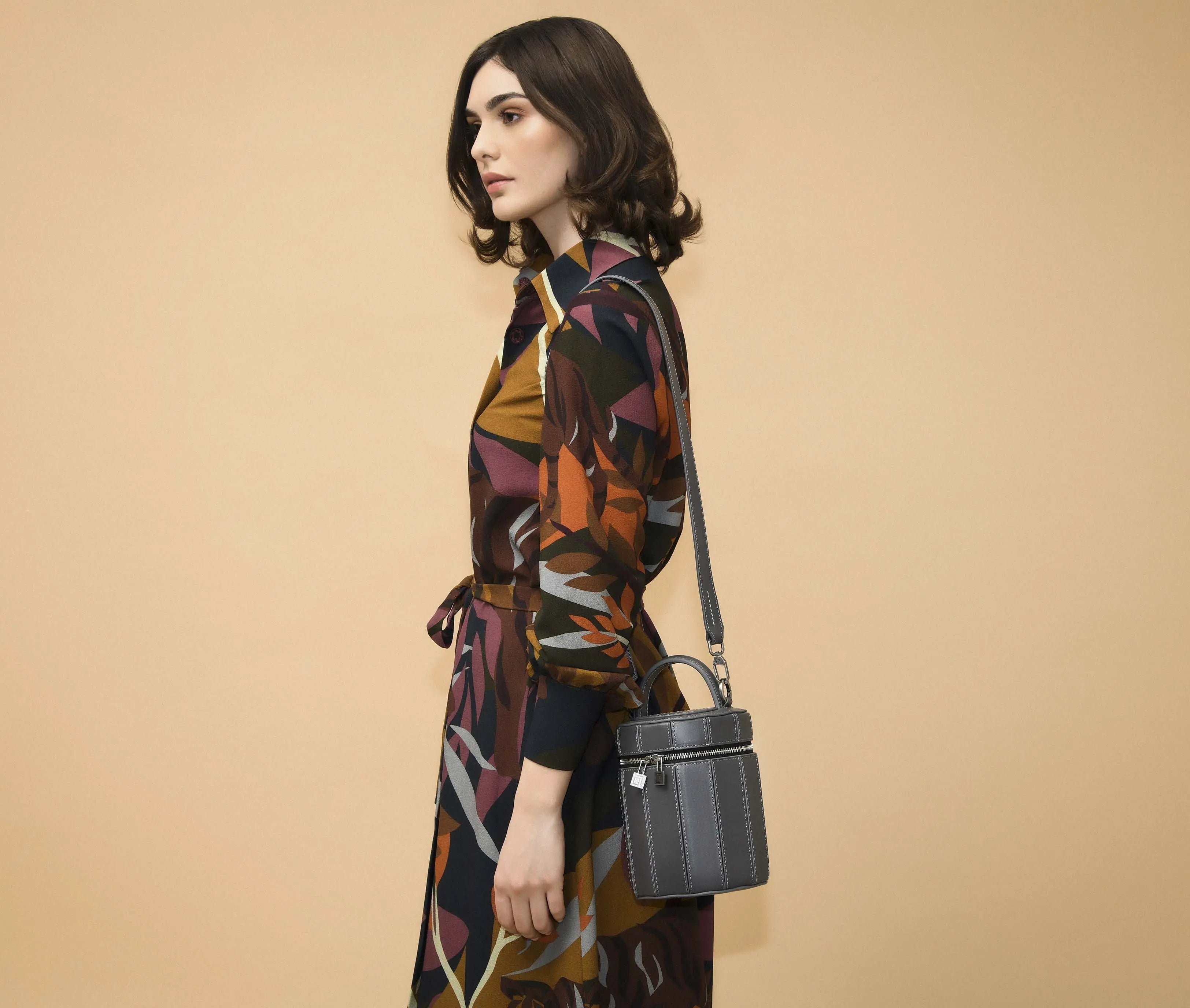 Model in a cream blazer carrying the Eleanor gray shoulder bag for a minimalist-chic look