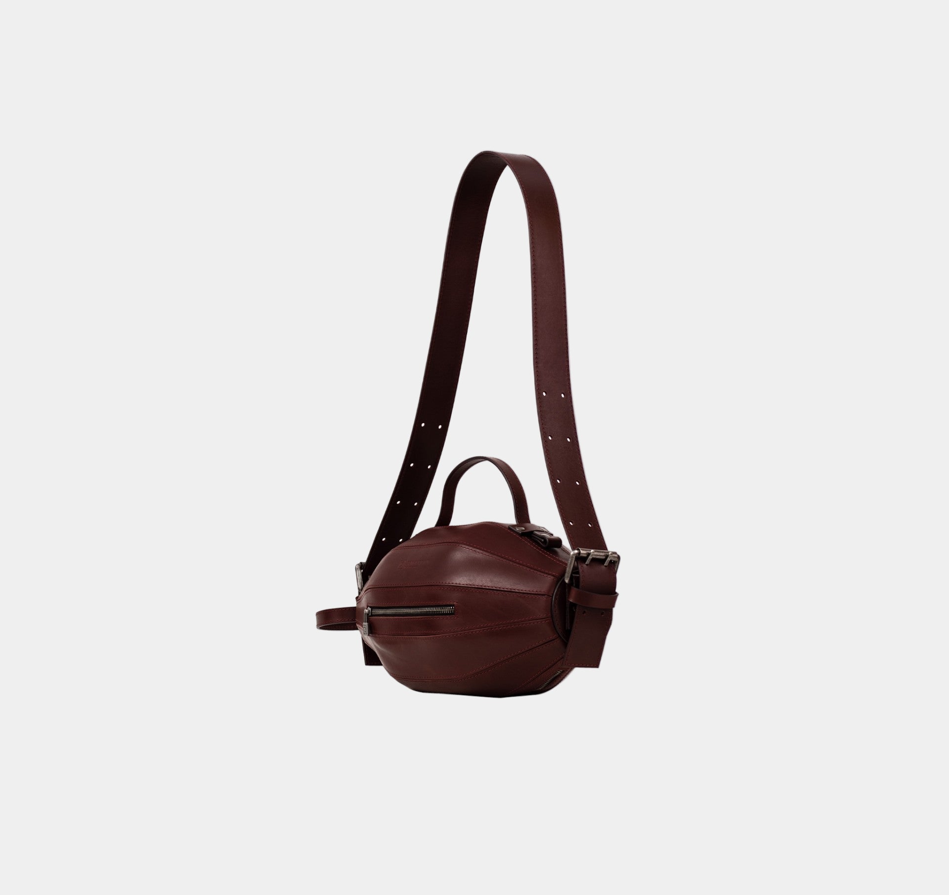 Side profile of the Ellisse Bag revealing its elliptical shape and depth.